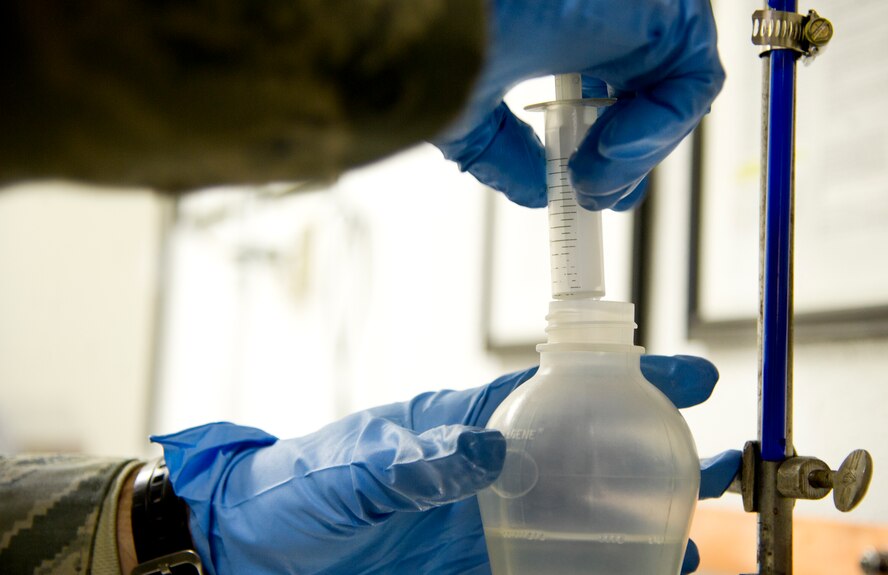 Senior Airman Cole Peck, 5th Logistics Readiness Squadron fuels laboratory technician conducts fuels testing for dryness, cleanliness and suitability for use at Minot Air Force Base, N.D., Dec. 10, 2013. The base fuels laboratory is responsible for the quality assurance and surveillance and testing of all petroleum products outlined by Department of Defense standards. (U.S. Air force photo/Senior Airman Brittany Y. Auld)