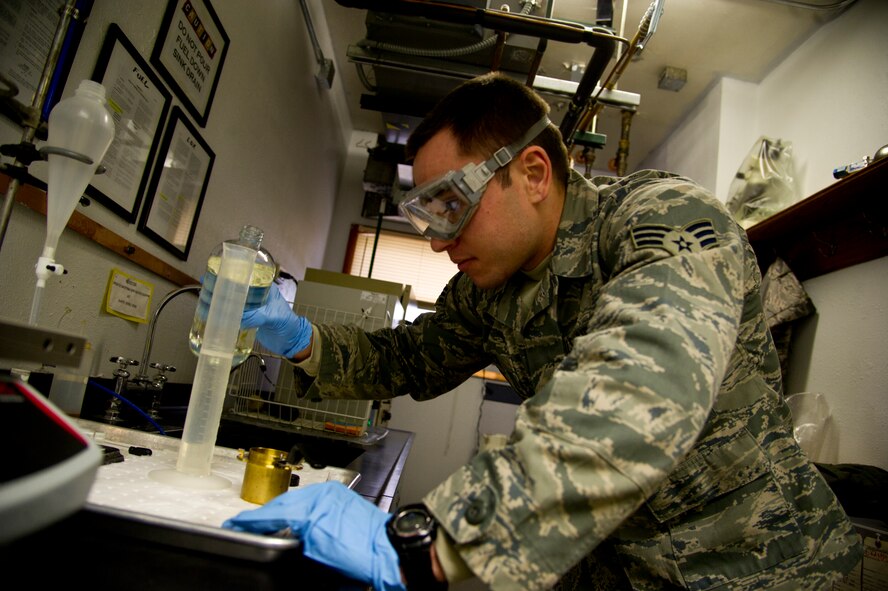 Senior Airman Cole Peck, 5th Logistics Readiness Squadron fuels laboratory technician, inspects a fuel sample for consistency prior to diagnostics testing at Minot Air Force Base, N.D., Dec. 10, 2013. At the base level, quality assurance and testing includes the receiving, storing and monitoring of jet fuel, liquid oxygen, and all ground fuels used at Minot AFB. (U.S. Air force photo/Senior Airman Brittany Y. Auld)