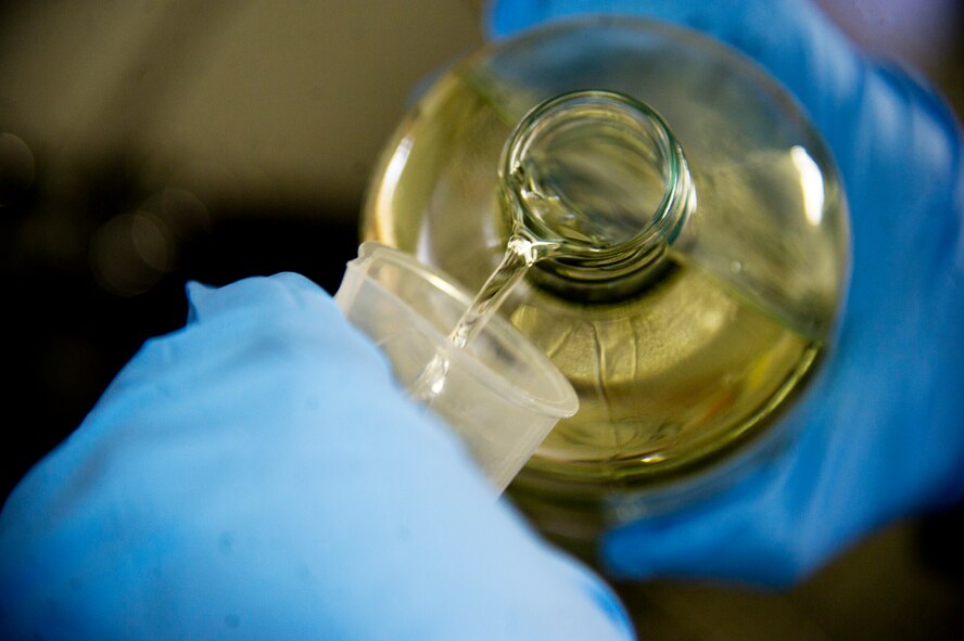 Senior Airman Cole Peck, 5th Logistics Readiness Squadron fuels laboratory, inspects a fuel sample for consistency prior to diagnostics testing at Minot Air Force Base, N.D., Dec. 10, 2013. The primary goal of the fuels laboratory is to make sure the fuel is a clean, quality product that meets all specifications, from the moment it arrives, to the moment it is loaded on an aircraft. (U.S. Air force photo/Senior Airman Brittany Y. Auld)