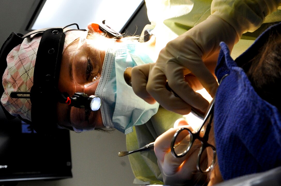 U.S. Air Force Maj. Melissa Fisher, 633rd Medical Group oral and maxillofacial surgeon, removes a patient’s wisdom teeth during oral surgery at Langley Air Force Base, Va., Jan. 2, 2014. In addition to oral surgery, Fisher is also able to offer some cosmetic surgeries at up to a 30 percent savings compared to off-base physicians. Fisher is a native of Decatur, Ill. (U.S. Air Force photo by Staff Sgt. Wesley Farnsworth/Released)