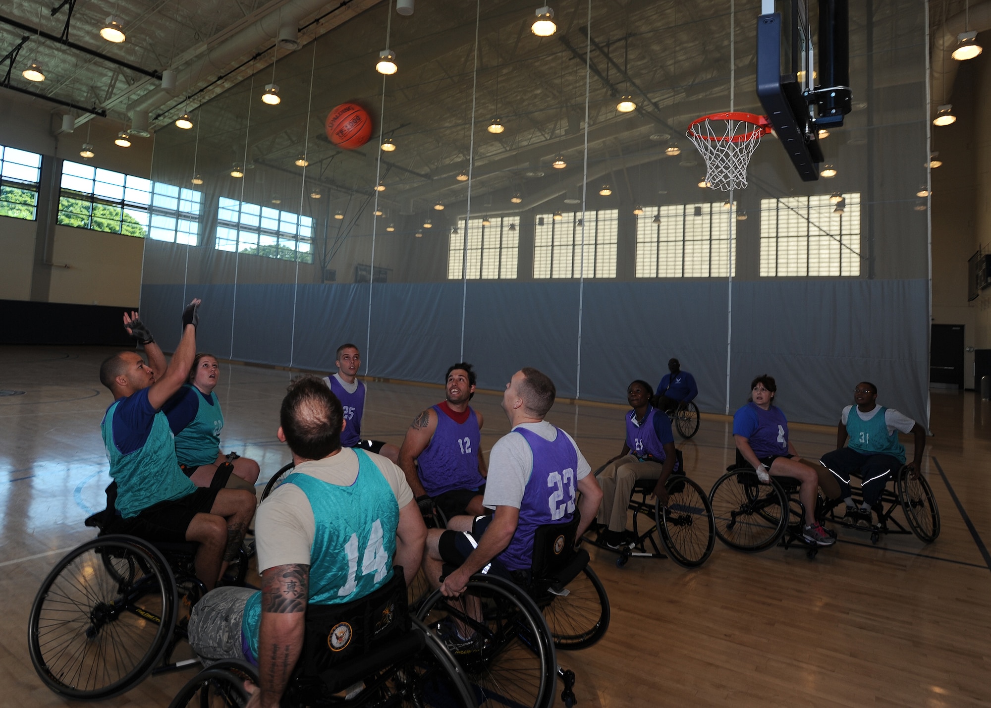 Team Hickam members play wheelchair basketball during an Air Force Adaptive Sports Program camp at Joint Base Pearl Harbor-Hickam Fitness Center, Hawaii, Jan 6. 2014. All enrollees in Air Force Wounded Warriors are encouraged to make athletics an essential part of their recovery, rehabilitation and rehabilitation plans. (U.S. Air Force photo/Master Sgt. Jerome S. Tayborn)