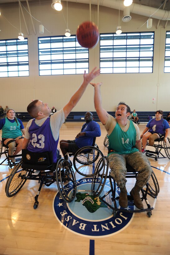 Team Hickam members play wheelchair basketball with Air Force wounded warrior during an Air Force Adaptive Sports Program camp, at Joint Base Pearl Harbor-Hickam Fitness Center, Hawaii, Jan. 6, 2014. The goal of the Air Force Wounded Warrior Adaptive Sports program is to introduce adaptive sports early on in the healing process in order to promote physical, social, emotional and spiritual healing. (U.S. Air Force photo/Master Sgt. Jerome S. Tayborn)