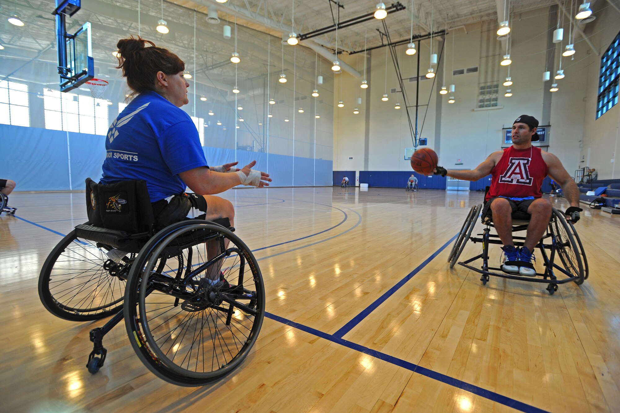 Air Force wounded warriors Maj. Lee Kuxhaus (Retired), left, prepares to accept a pass from Tech. Sgt. Ryan Pinney, right, during an adaptive sports program camp at Joint Base Pearl Harbor-Hickam Fitness Center, Hawaii, Jan. 6, 2014. The athletes are here to compete in the 2014 Wounded Warrior Pacific Invitational which will pit more than 120 warriors against each other in cycling, seated volleyball, swimming, wheelchair basketball and track and field. (U.S. Air Force photo/Master Sgt. Jerome S. Tayborn)