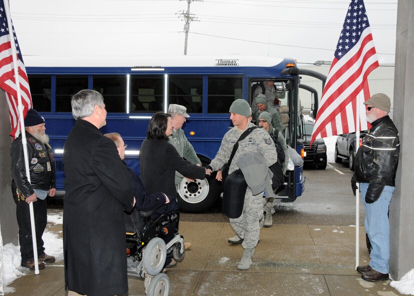 Airmen from the 143d Airlift Wing returning from a deployment to Kuwait are greeted by Rhode Island military and political leaders as well as a flag detail provided by the Combat Veterans Motorcycle Association. Family, firends and fellow Airmen waited inside to welcome the Airmen home. National Guard Photo by Master Sgt John McDonald (RELEASED)