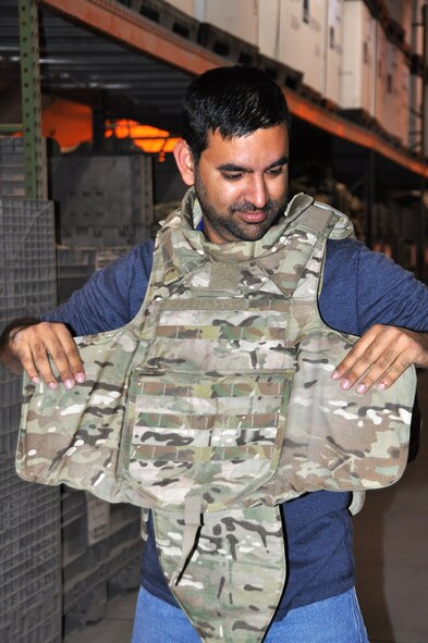 Sagar Pathak, creator of Horizontal Rain aviation blog, tries on an armored vest at the Expeditionary Theater Distribution Center at the Transit Center at Manas, Kyrgyzstan. Pathak was on the ground for three days to document aircraft and the refueling mission.  (U.S. Air Force photo by 2nd Lt. Rachelle Smith/Released)