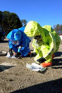 U.S. Air Force Airman 1st Class Zachary Day, 633rd Civil Engineer Squadron emergency manager, and Senior Airman Felicia Still, 633rd Aerospace Medical Squadron bioenvironmental engineering technician, test for explosive-borne contamination during a hazardous material exercise at Langley Air Force Base, Va., Dec. 18, 2013. The exercise examined how emergency management and bioenvironmental engineering personnel work together during a HAZMAT crisis. (U.S. Air Force photo by Senior Airman Brittany Paerschke-O’Brien/Released)
