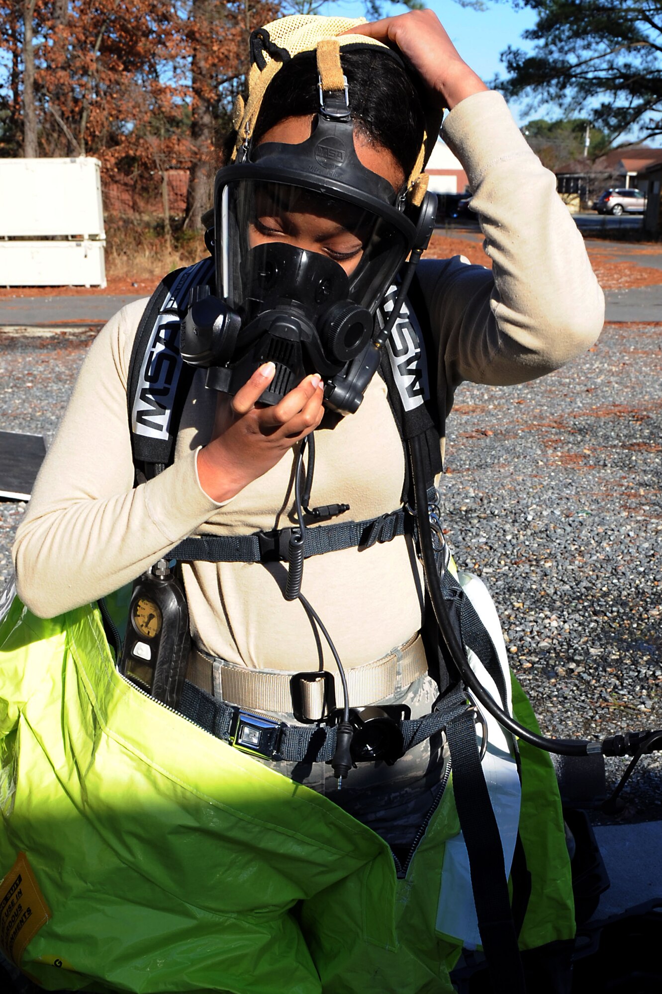 U.S. Air Force Senior Airman Felicia Still, 633rd Aerospace Medical Squadron bioenvironmental engineering technician, dons her gas mask during a hazardous material exercise at Langley Air Force Base, Va., Dec. 18, 2013. The exercise aimed to enhance emergency response operations in the event of a real-world crisis. (U.S. Air Force photo by Senior Airman Brittany Paerschke-O’Brien/Released)