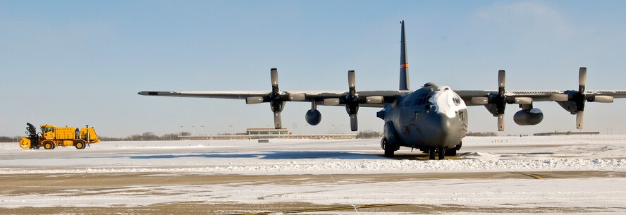 An engineer with the 182nd Civil Engineer Squadron plows snow from the mass aircraft parking area during bitter cold weather conditions at the 182nd Airlift Wing in Peoria, Ill., Jan. 6, 2014. The Illinois Air National Guard Base experienced minus 35 degrees Fahrenheit wind chills and wind gusts of up to 36 mph Monday when an arctic air mass crossed the central and eastern U.S., according to the National Weather Service. Despite the extreme environmental conditions, the installation remained open and ready to complete its state and federal missions. (U.S. Air National Guard photo by Staff Sgt. Lealan Buehrer/Released)