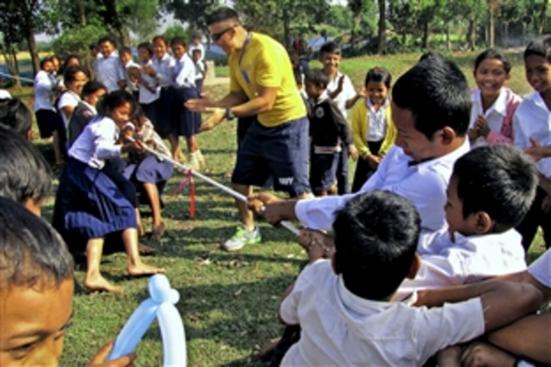 U.S. Navy Petty Officer 3rd Class Mario Roman teaches tug-of-war to children in Cambodia, Jan. 5, 2013. Roman is part of a team with a mission to conduct civic assistance projects and community relations events to help enhance shared capabilities and improve the country's social welfare. Roman is assigned to Naval Mobile Construction Battalion 3, Construction Civic Action Detail.