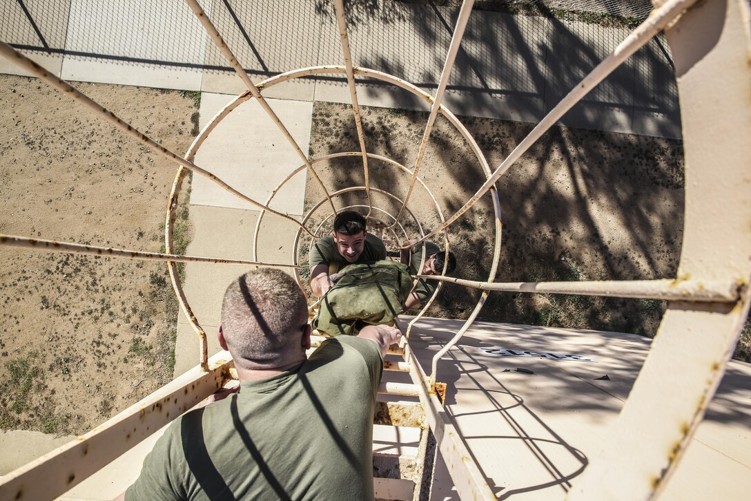 Sergeant Jonathan Ayala, cyber network operator, hands radio antenna equipment to Staff Sgt. Christopher M. Phibbs, cyber network chief, both with the 15th Marine Expeditionary Unit, during a communications exercise aboard Camp Pendleton, Calif., Jan. 6, 2014. The exercise is designed to prepare 15th MEU Marines for Exercise Iron Fist. (U.S. Marine Corps photo by Cpl. Emmanuel Ramos/Released) 