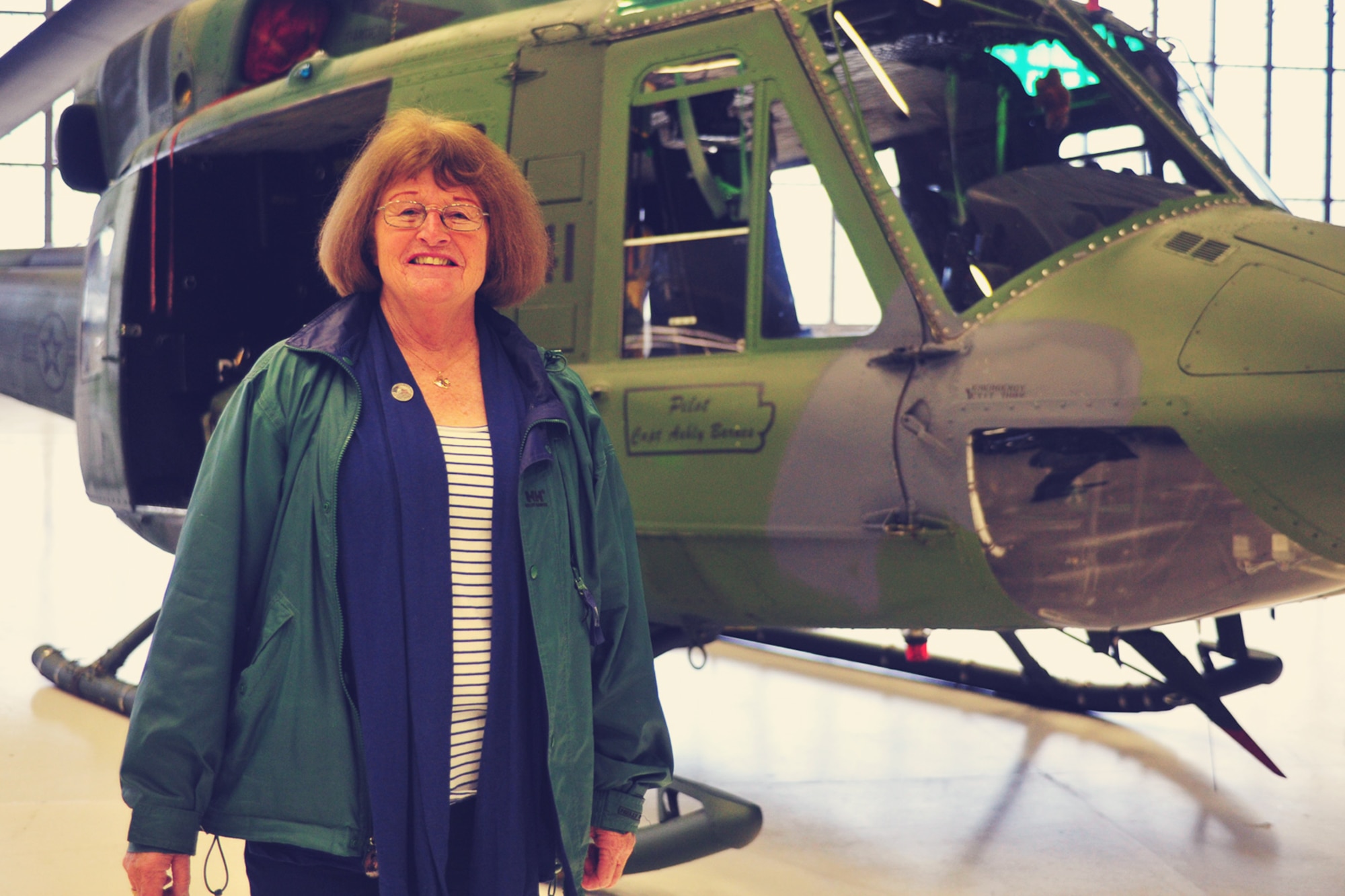 George “Julie” Kubat, an Air Force spouse and a member of the Fairchild Air Force Base family for roughly 40 years, stands in front of a helicopter at the Veterans Day ceremony Nov. 7, 2013 at Fairchild Air Force Base, Wash. Kubat shares the story of her early years which began in an Indonesian ‘prisoner of war’ camps with her mother. (U.S. Air Force/Senior Airman Taylor Curry) 