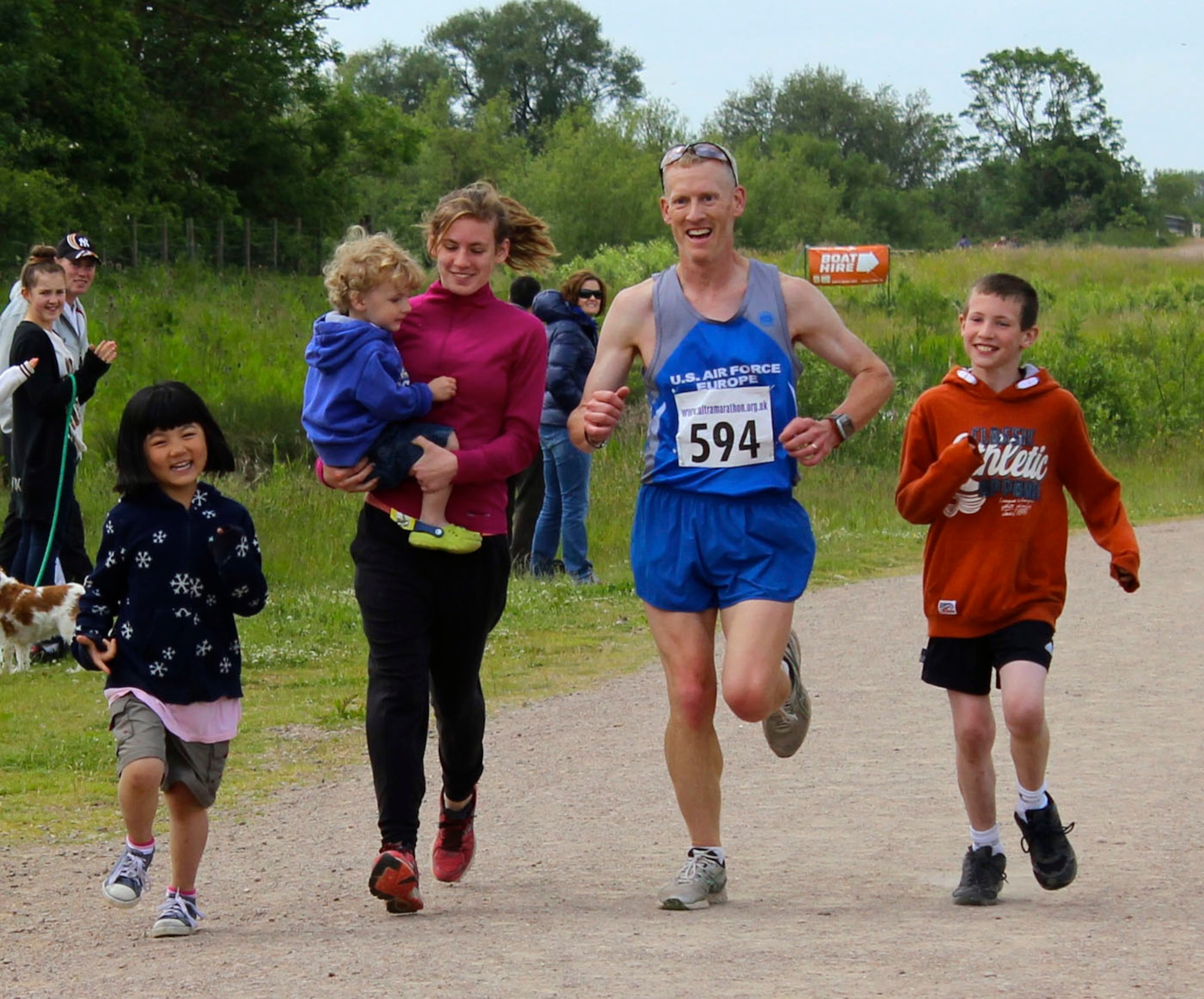 Lt. Col. Christopher Bennett, second from right, prepares to cross the finish line of the Alexander the Great half-marathon on Father's Day, June 16, 2013, at Stanwick Lakes, Northamptonshire, England. As part of a family tradition, Bennett's children (from left to right) Emma, Ashton, Katie Reed and Elijah run with their dad every Father's Day. Bennett is the chief of airlift and tanker requirements (Courtesy photo/Molly Bennett)