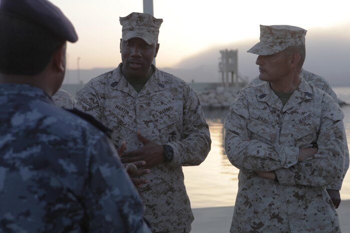 Master Gunnery Sgt. Quincy M. Martin, the communications chief with U.S. Marine Corps Forces Central Command (Forward), and Sgt. Maj. Mario A. Marquez, the sergeant major of MARCENT (Fwd), discuss the Royal Jordanian Armed Forces naval capabilities with Wakeel Khalaf Almarayeh, a command chief petty officer in the JAF, during a tour of the Royal Jordanian Naval Base, Aqaba, Jordan, June 12, 2013.