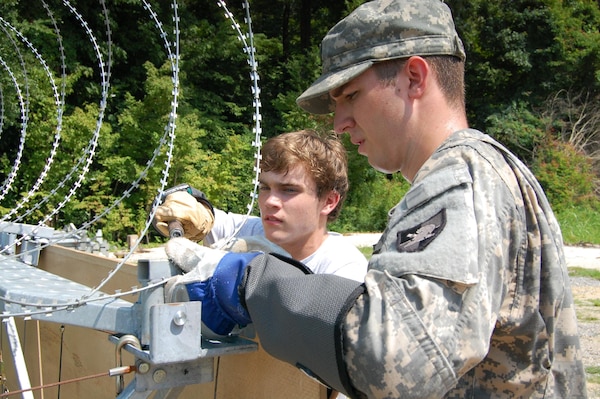 Cadet Matthew Shoenberger works with concertina wire alongside an ERDC PATHWAYS student as part of his Summer 2012 stint researching survivability technology in the Geotechnical and Structures Laboratory. 