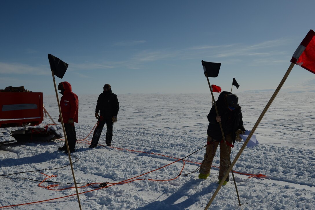 On right, ERDC Cold Regions Research and Engineering Laboratory’s Dr. Zoe Courville marks a crevasse snow bridge for blasting while on a recent Antarctic traverse to refuel the South Pole Station.