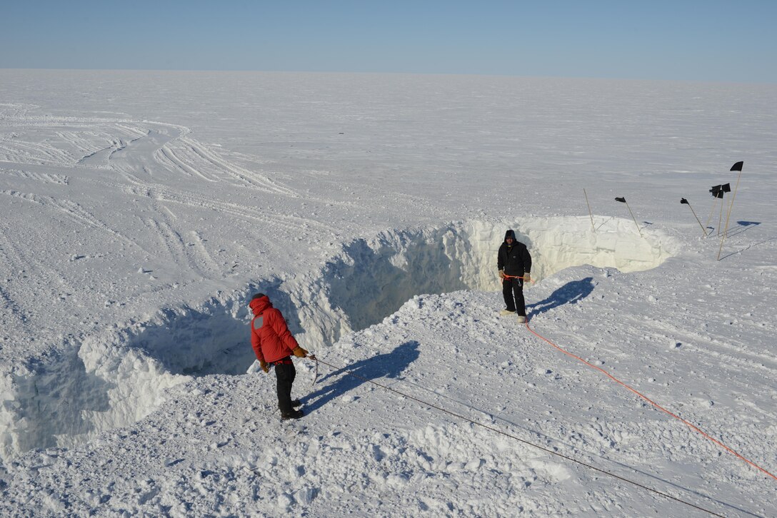 ERDC Cold Regions Research and Engineering Laboratory researchers on a recent Antarctic traverse, stand by a just blasted open crevasse. The open crevasse will be filled with snow and left safe to travel over.