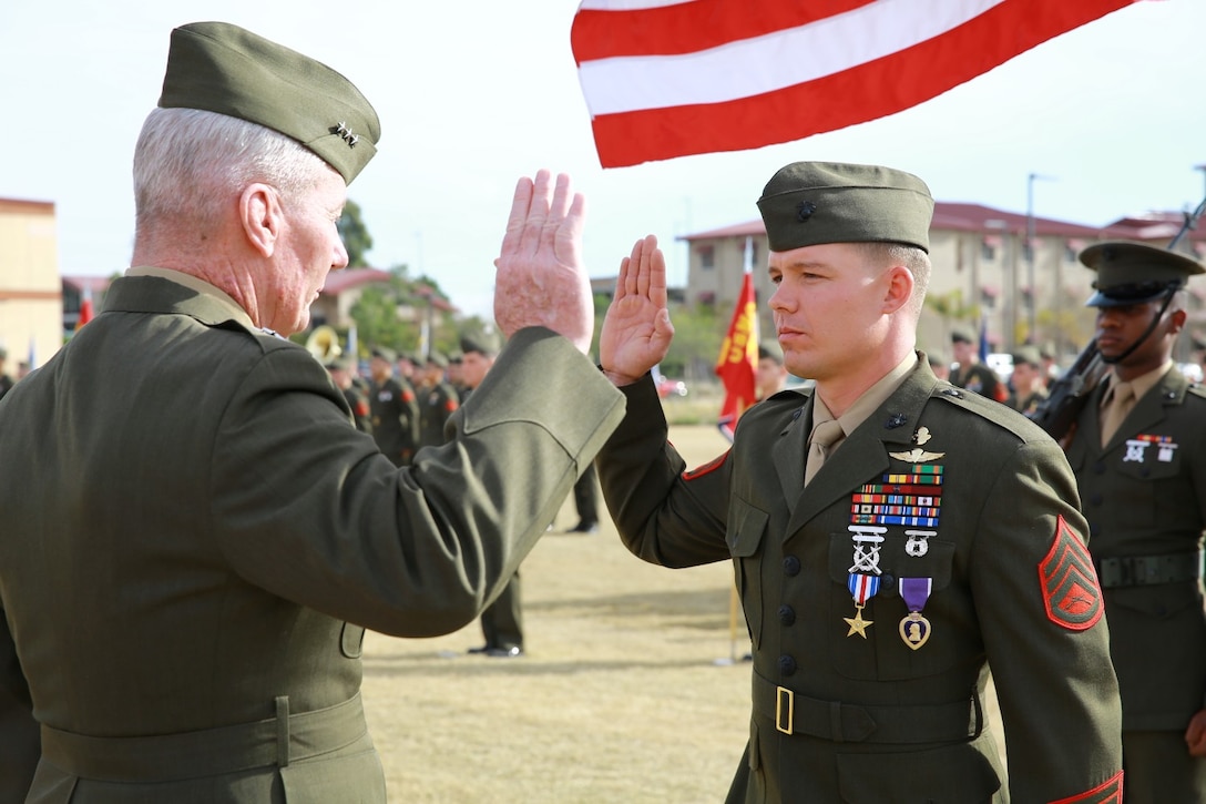 Lieutenant Gen. John Toolan, commanding general of I Marine Expeditionary Force, oversees the reenlistment of Staff Sgt. Timothy Williams, a section leader with 1st Reconnaissance Battalion, during an award ceremony held at Camp Las Flores, Marine Corps Base Camp Pendleton Calif., Jan. 7, 2014. Williams, a native of Hudson, Mich., was awarded the Silver Star Medal and Purple Heart for his heroic actions in Afghanistan when he maintained a tactical advantage while being ambushed by a larger enemy force. Williams helped save the lives of multiple Marines and destroyed several enemy positions during the 10 hour attack. (U.S Marine Corps photo by Lance Cpl. Jonathan Boynes/released)