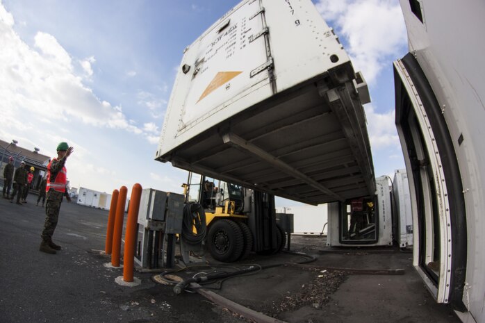 Cpl. Aaron Barbosa, a mobile facilities technician with Marine Aviation Logistics Squadron 12, directs a forklift that is lifting a mobile facility, Jan. 6, 2014. Staff Sgt. Jeremy Stuempert, assistant mobile facilities coordinator with MALS-12, said that the avionics division of MALS-12 is scheduled to complete their move in two weeks.