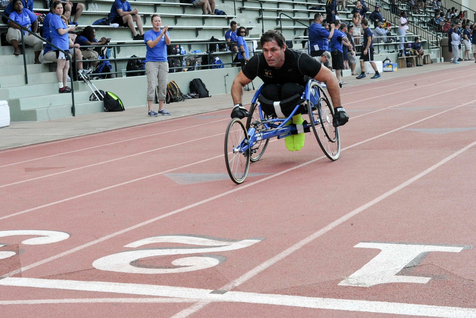 Retired Tech. Sgt. Ryan Pinney races to the finish line during the 100-meter wheelchair race during the track and field competition of the inaugural Wounded Warrior Pacific Invitational in Honolulu, Hawaii, Jan. 8, 2014. The race is part of the adaptive athletic reconditioning program which helps wounded warriors build strength and endurance, while they draw inspiration from their teammates. All enrollees in Air Force Wounded Warriors program are encouraged to make athletics an essential part of their recovery, rehabilitation and rehabilitation plans. (U.S. Air Force photo/Tech. Sgt. Terri Paden)