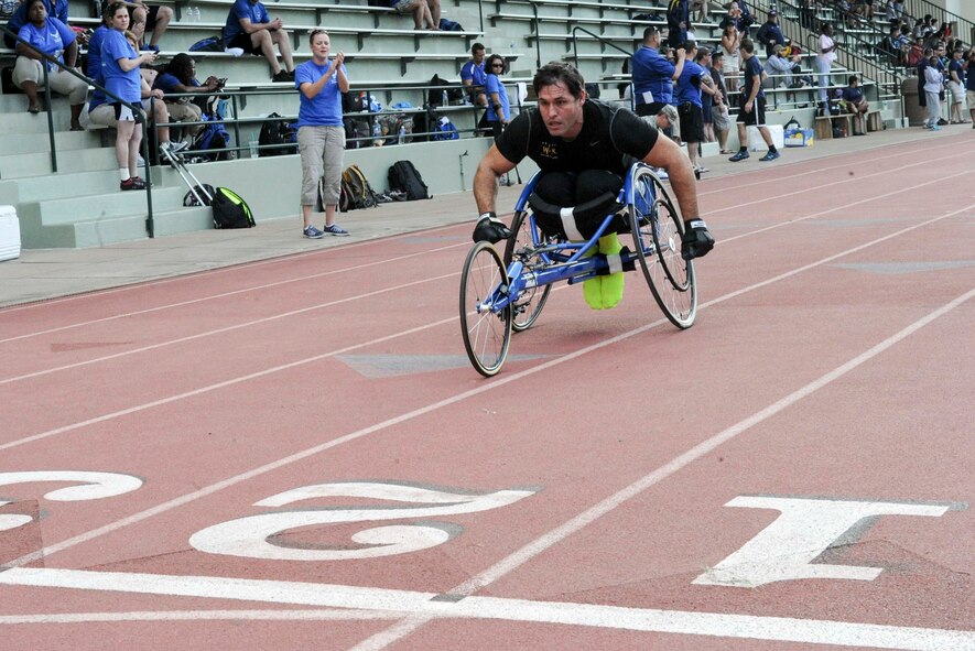 Retired Tech. Sgt. Ryan Pinney races to the finish line during the 100-meter wheelchair race during the track and field competition of the inaugural Wounded Warrior Pacific Invitational in Honolulu, Hawaii, Jan. 8, 2014. The race is part of the adaptive athletic reconditioning program which helps wounded warriors build strength and endurance, while they draw inspiration from their teammates. All enrollees in Air Force Wounded Warriors program are encouraged to make athletics an essential part of their recovery, rehabilitation and rehabilitation plans. (U.S. Air Force photo/Tech. Sgt. Terri Paden)
