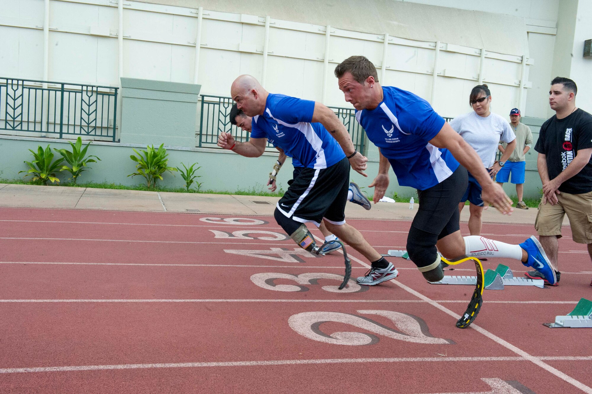 Air Force wounded warriors take off for the men’s 100-meter dash event during the track and field competition of the inaugural Wounded Warrior Pacific Invitational in Honolulu, Hawaii, Jan. 8, 2014. The goal of the Air Force Wounded Warrior Adaptive Sports program is to introduce adaptive sports early on in the healing process in order to promote physical, social, emotional and spiritual healing. (U.S. Air Force photo/Tech. Sgt. Terri Paden)