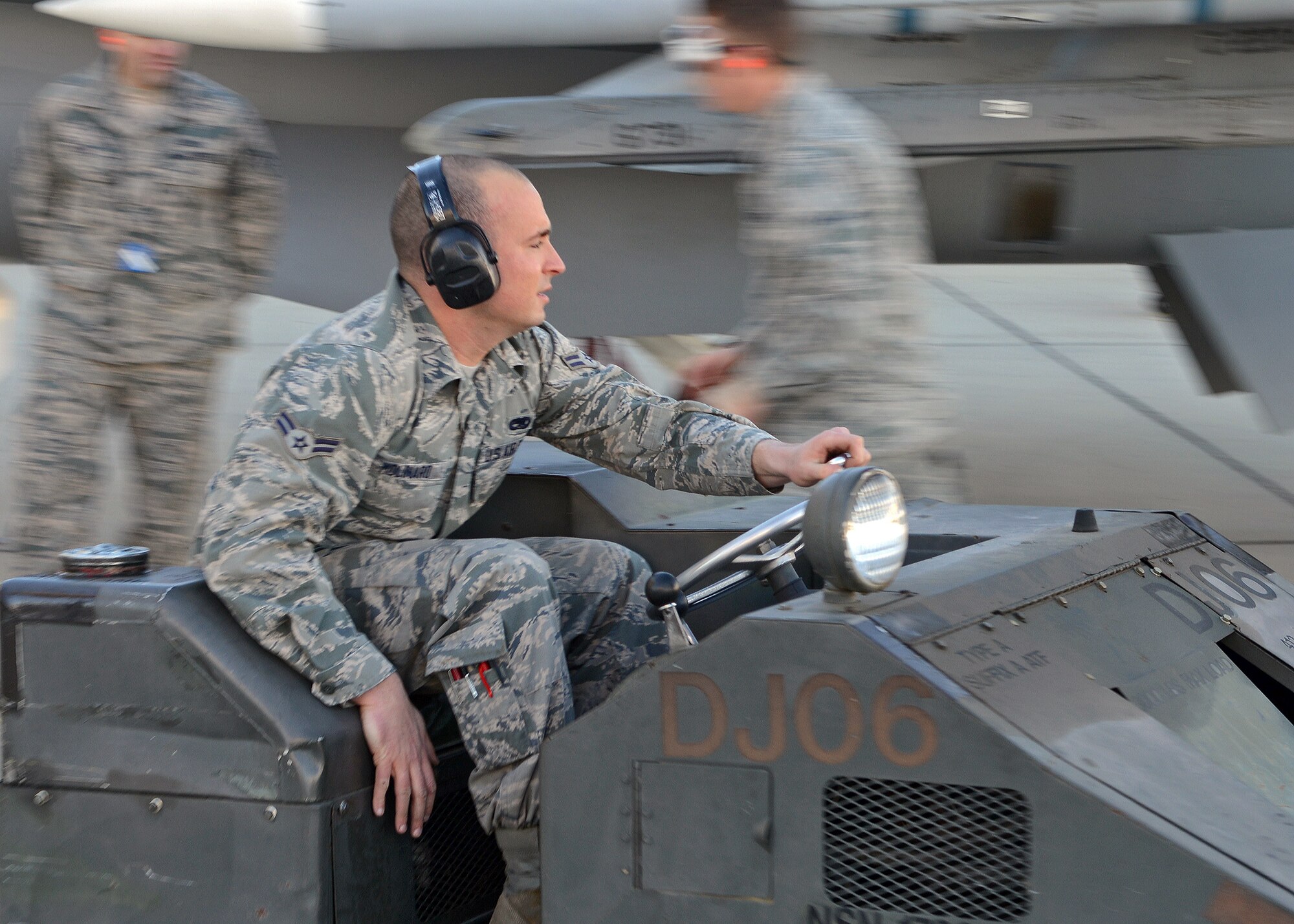 Airman 1st Class Briano Molinaro drives his MJ-1B munitions loader past inspectors in order to pick up his team’s next munition during the Fourth Quarter Fighter Weapons Load Competition Jan. 6, 2014, behind Hangar 1600. Airman Molinaro is a 412th Aircraft Maintenance Squadron weapons load crew member who represented the 445th Aircraft Maintenance Unit during the competition. (U.S. Air Force photo by Jet Fabara)
