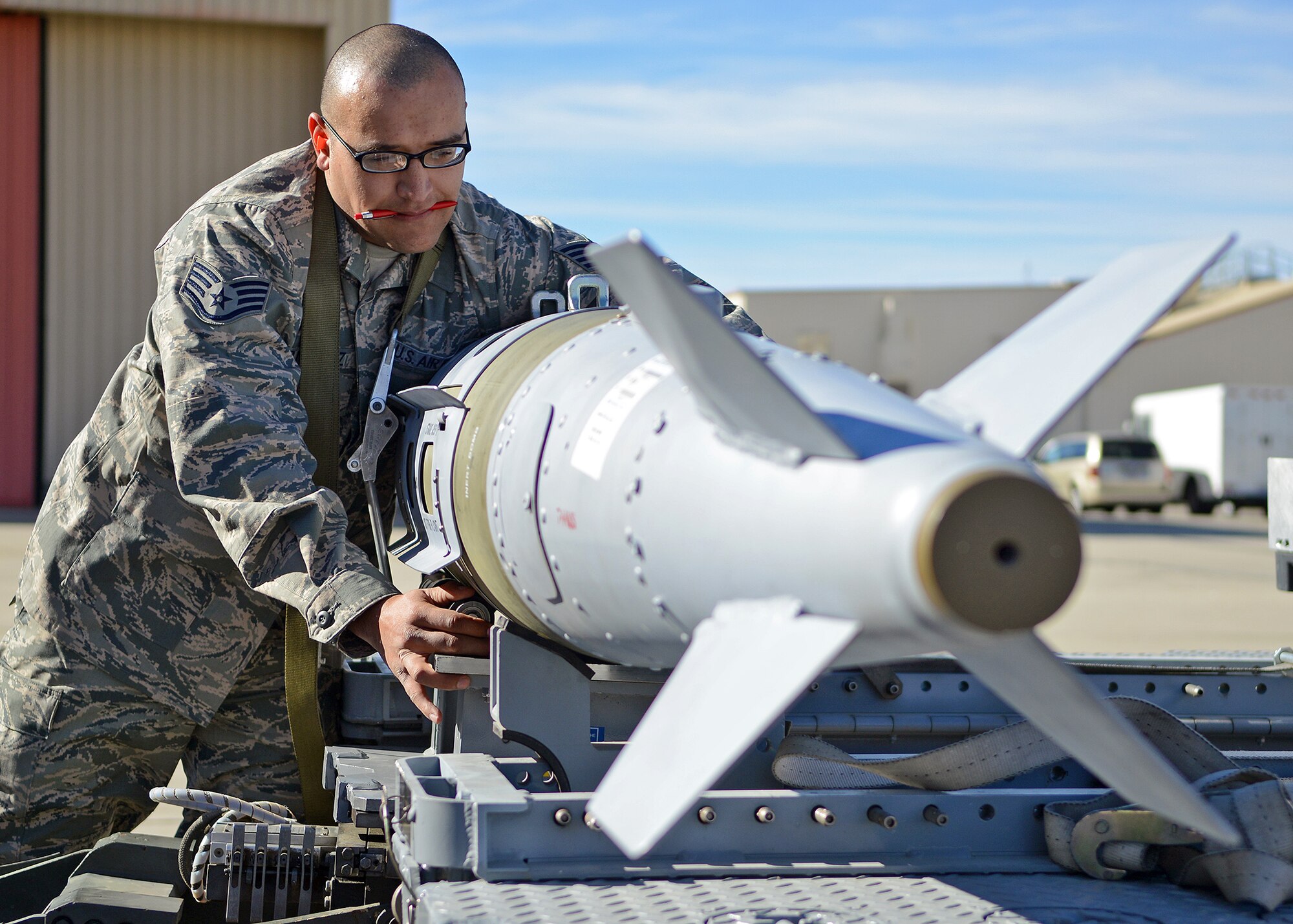 Staff Sgt. Toby Hernandez ensures the MJ-1B munitions loader driver secures a GBU-32 before loading it to an F-22 Raptor during the Fourth Quarter Fighter Weapons Load Competition Jan. 6, 2014 behind Hangar 1600. Sergeant Hernandez is the 411th Aircraft Maintenance Unit weapons team chief. (U.S. Air Force photo by Jet Fabara)