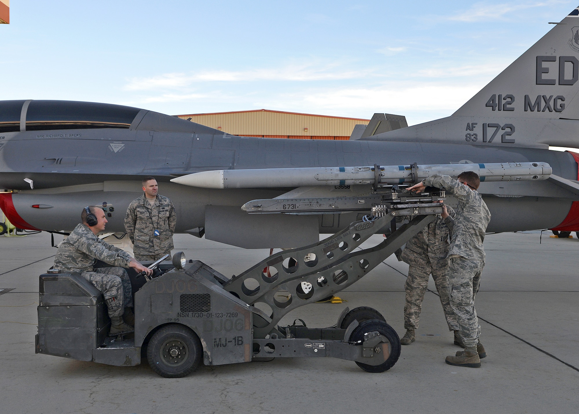Weapons load crew members with the 445th Aircraft Maintenance Unit load an F-16 Falcon during the Fourth Quarter Fighter Weapons Load Competition Jan. 6, 2014. Weapons load crew members from the 445th, 411th and 461st AMU competed in the friendly competition to showcase each crew member’s talent. Of the three units, the 445th AMU claimed the fourth quarter trophy. (U.S. Air Force photo by Jet Fabara)