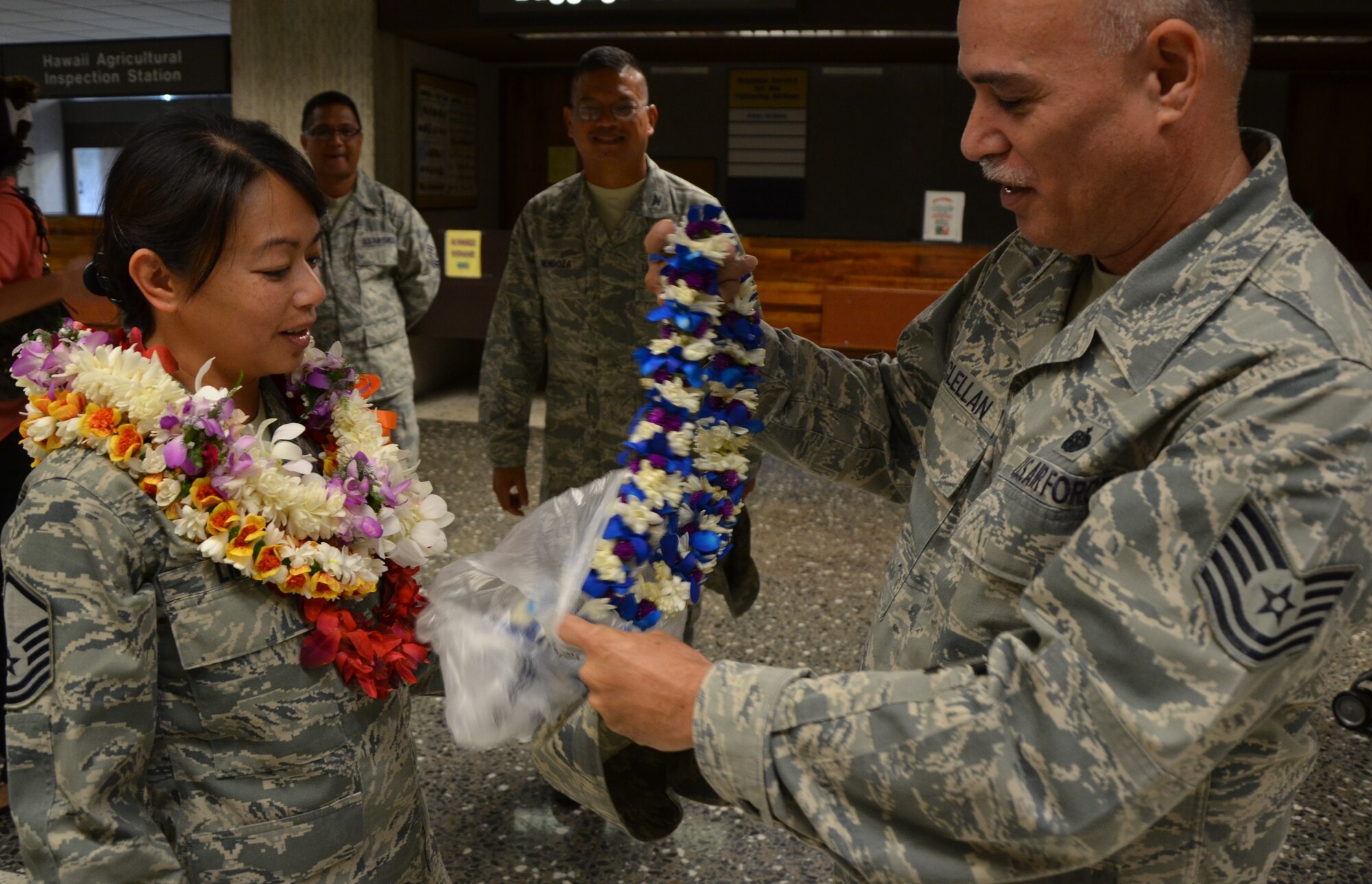 Master Sgt. Chris Lim, left, a knowledge operations manager (KOM) with the 48th Aerial Port Squadron, 624th Regional Support Group, Joint Base Pearl Harbor-Hickam, Hawaii, is presented with a traditional Hawaiian lei from Tech. Sgt. Archie McClellan, right, KOM with the 624th RSG, upon her return from deployment, Honolulu International Airport, Honolulu, Hawaii, Jan. 7, 2014. Lim volunteered for her assignment to the 340th Expeditionary Air Refueling Squadron at Al Udeid Air Base, Qatar in support of Operation Enduring Freedom. During her deployment, Lim contributed to the largest air refueling squadron in the world that uses the Total Force Integration (TFI) model with approximately 1,200 personnel rotating from the Air Force Reserve, Air National Guard, and active duty each year. (U.S. Air Force photo by Tech. Sgt. Phyllis Keith)