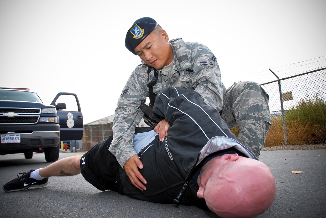 U.S. Air Force Airman 1st Class William DeGuzman, 129th Security Forces specialist, performs integrated base defense measures during a training scenario at the 129th Rescue Wing, Moffett Federal Airfield, Calif., Nov. 14, 2013.  (U.S. Air National Guard photo by Tech. Sgt. Ray Aquino/RELEASED)