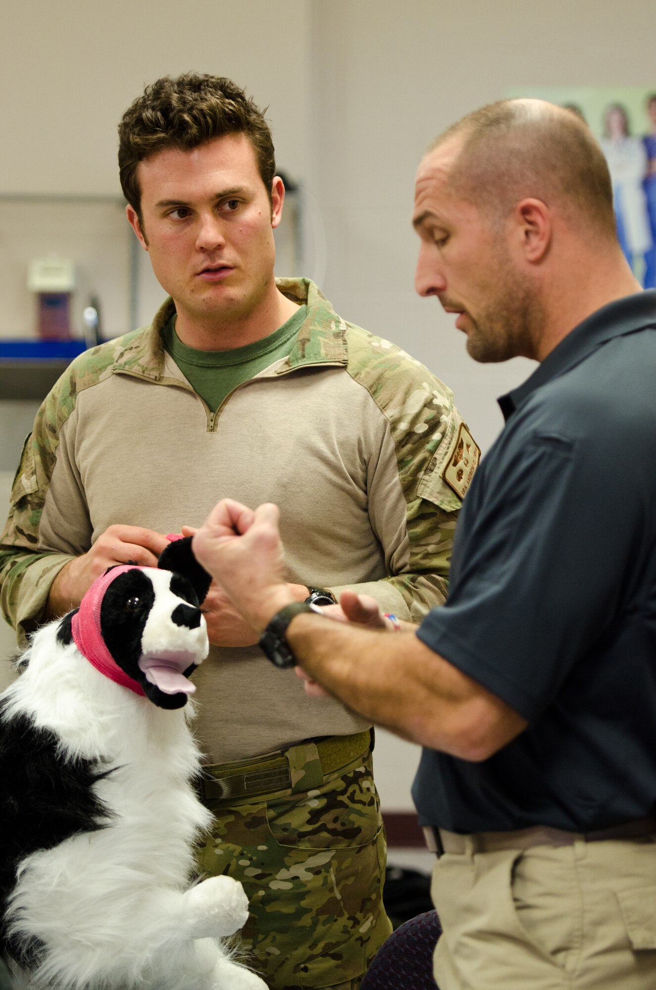 Thomas Barrett (right), a civilian paramedic and K9 medic trainer, speaks to Senior Airman Andrew Zina, a pararescueman from the Kentucky Air National Guard’s 123rd Special Tactics Squadron, about how to properly bandage and care for a military working dog that is wounded on the battlefield during a training course Dec. 5, 2013, at Jefferson Community College in Shelbyville, Ky. Barrett is one of 10 Kentucky Air Guard pararescuemen who learned to treat military working dogs during the two-day course. (U.S. Air National Guard photo by Master Sgt. Phil Speck)