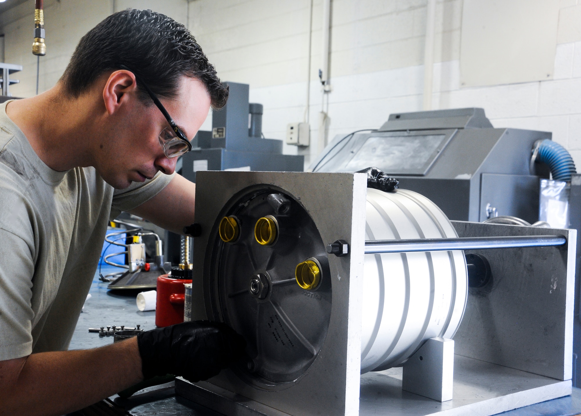 U.S. Air Force Staff Sgt. James Boslooper, 355th Component Maintenance Squadron hydraulic systems craftsman, screws a protective cap on a bootstrap reservoir before transport at Davis-Monthan Air Force Base, Ariz., Jan. 7, 2014. Hydraulic back shops around the Air Force are responsible for preparing, disassembling and repairing hydraulic systems and parts for multiple airframes. (U.S. Air Force photo by Senior Airman Sivan Veazie/Released)