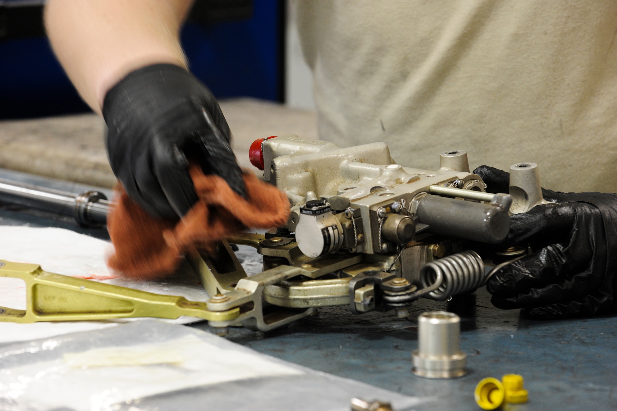 U.S. Air Force Staff Sgt. Alexander Pruitt, 355th Component Maintenance Squadron hydraulic systems craftsman, cleans an A-10 Thunderbolt II’s rudder actuator at Davis-Monthan Air Force Base, Ariz., Jan. 7, 2014. The rudder actuator is a flight control system that operates the movement of the rudder on the aircraft. (U.S. Air Force photo by Senior Airman Sivan Veazie/Released)