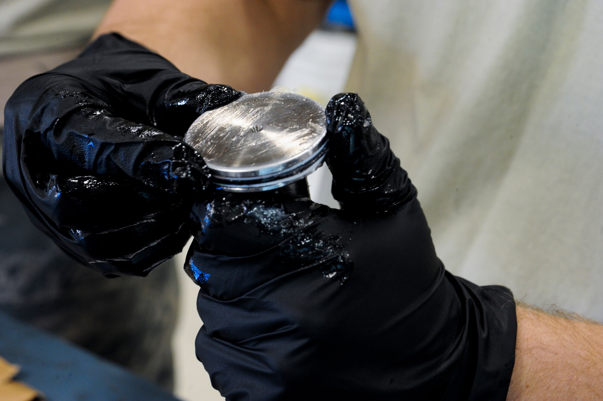 U.S. Air Force Airman 1st Class Zackary Huebner, 355th Component Maintenance Squadron hydraulic systems apprentice, lubes an aircraft part at Davis-Monthan Air Force Base, Ariz., Jan. 7, 2014. Most aircraft parts are lubed for installment and to help their in-flight systems and parts function properly. (U.S. Air Force photo by Senior Airman Sivan Veazie/Released)