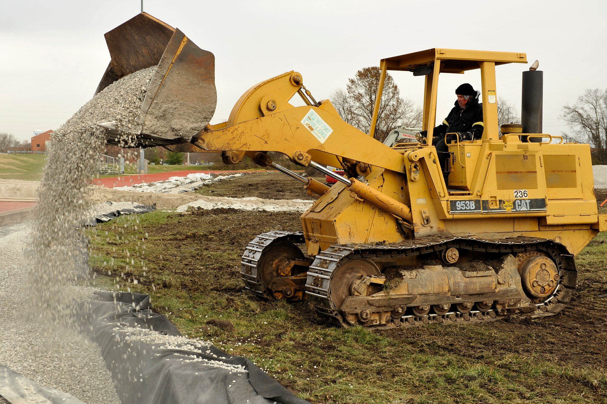 A construction worker begins filling a drainage with rocks at the James Gym track Nov.25 at Scott Air Force Base, Ill. AstroTurf, a synthetic turf, is being placed on the inside of the track. Renovations for the track began Nov. 18, 2013, and will continue until Mar. 1, 2014. (U.S. Air Force photo/Airman 1st Class Jaeda Waffer)