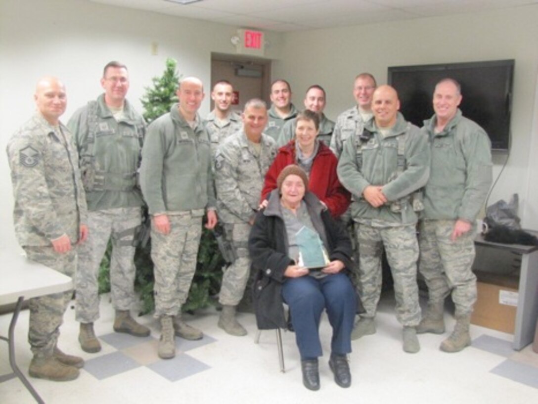 From left to right, Master Sgt. Ken Craft, Master Sgt. Patrick Hendershot, Staff Sgt. Judson Heckerman, Tech. Sgt. Michael Wenger, Master Sgt. Joseph Snyder, Tech. Sgt. James Hindinger, Staff Sgt. Lee Crusa, Capt. Randall Gernhardt, Tech. Sgt. Aaron Lopez, and Senior Master Sgt. Bruce Zimmerman present retired Tech. Sgt. Mary Howell and Howell’s mother Kathleen Cockerham (seated), with a plaque in recognition of their kind and continued support.  