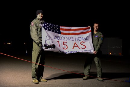 Two Airmen from the 15th Airlift Squadron hold a welcome home banner for their wingmen Jan. 6, 2014, at Joint Base Charleston — Air Base, S.C. More than 80 Airmen from the 15th AS returned from a 60-day deployment to Southwest Asia. (U.S. Air Force photo/Airman 1st Class Clayton Cupit)