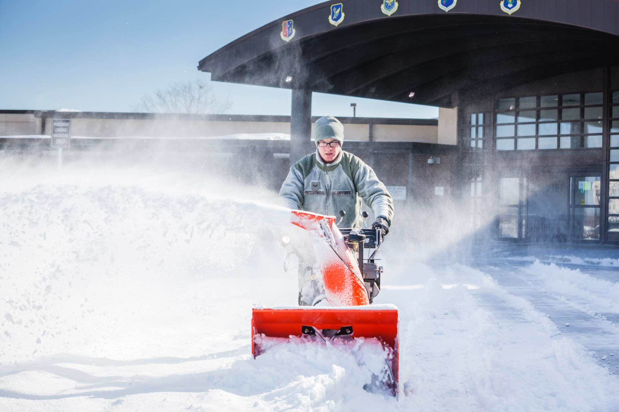 Airman 1st Class Thomas Gutherman, 305th Aerial Port Squadron Passenger Terminal service representative uses a snow blower to remove snow from the passenger-loading area in front of the Passenger Terminal Jan. 3, 2014, at Joint Base McGuire-Dix-Lakehurst, N.J. A snow storm left approximately 8 inches of snow on the base roads and cause airfield operations to shut down for approximately 15 hours. (U.S. Air Force photo by Wayne Russell/Released)