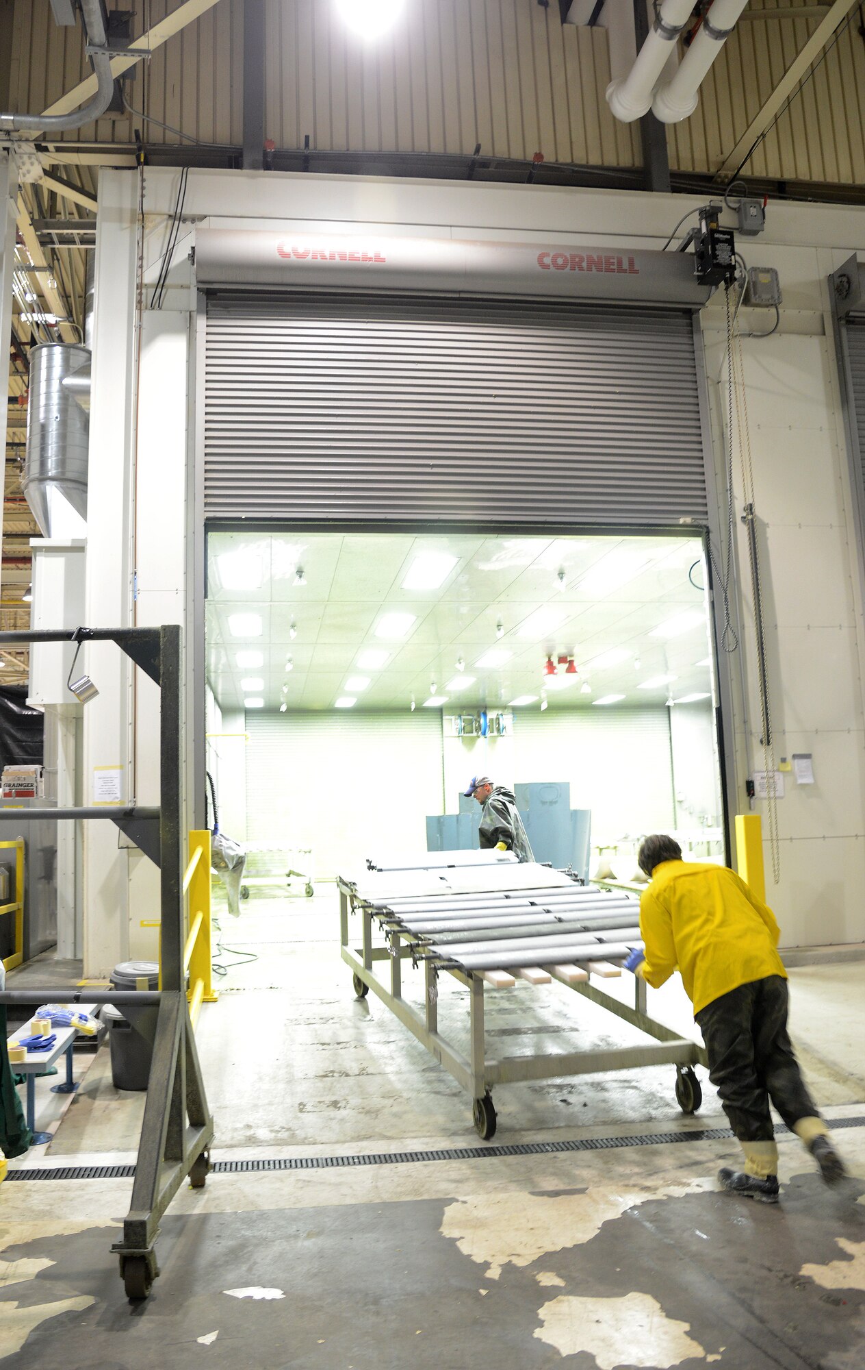 David Grogan, left, and Jason Brunk, equipment cleaners in the 566th Aircraft Maintenance Squadron, push parts into a paint stripping booth in Bldg. 9001. The two booths recently received significant energy-efficient and ventilation upgrades. (Air Force photo by Kelly White)