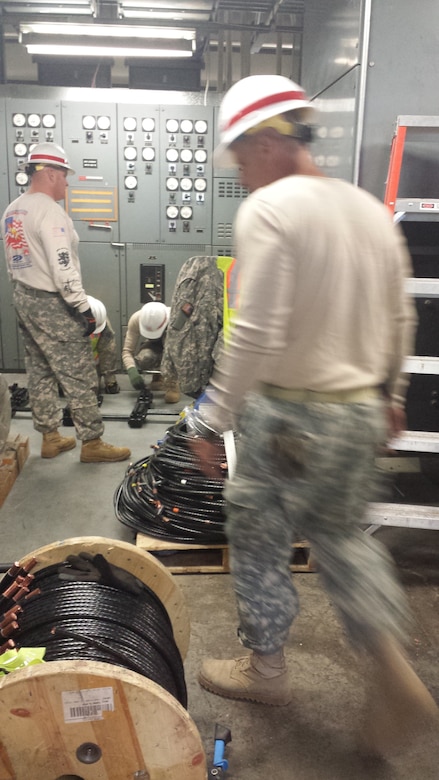 The 249th Engineer Battalion running power cables in a switchgear room. 