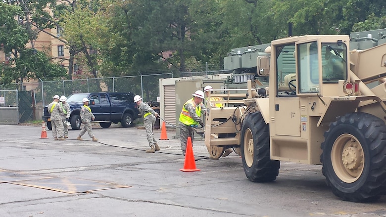 The 249th Engineer Battalion prepares cables for connection to generator. 