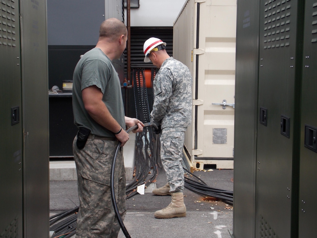 The 249th Engineer Battalion feeding cable through an access hole. 