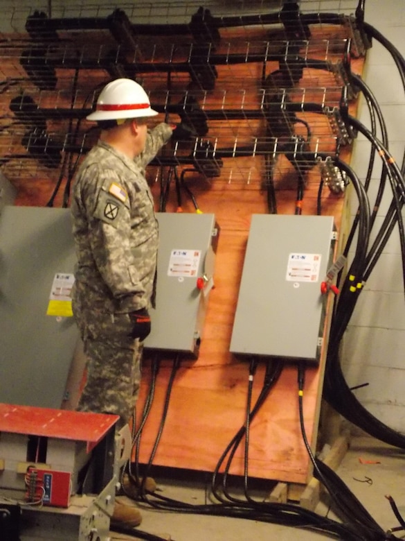 A member of the 249th Engineer Battalion inspecting connections. 