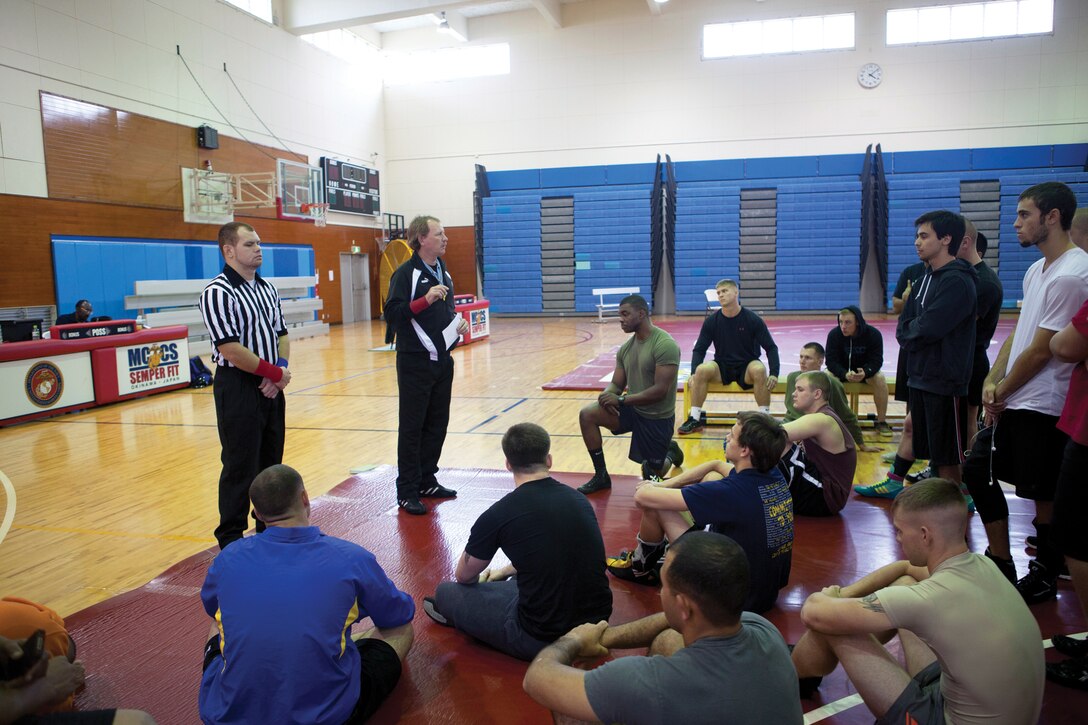 Steve C. Schrock, standing second from left, briefs wrestling participants on safety guidelines developed by the International Federation of Associated Wrestling Styles Jan. 4 at Marine Corps Air Station Futenma’s Semper Fit Gym during the Futenma Athletics Open Wrestling Tournament. Schrock is an official referee for the tournament. (U.S. Marine Corps photo by Lance Cpl. Diamond N. Peden/Released)