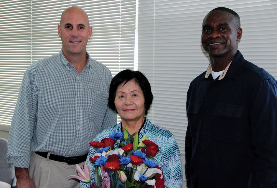 Keiko Onaga, center, stands with Col. James G. Flynn, left, and Sgt. Maj. Delvin R. Smythe thanking Onaga for her 44 years of dedicated service Dec. 18 at the Marine Corps Air Station Futenma Chaplain’s Office. Flynn is the commanding officer, and Smythe is the sergeant major of MCAS Futenma. (Courtesy photo)