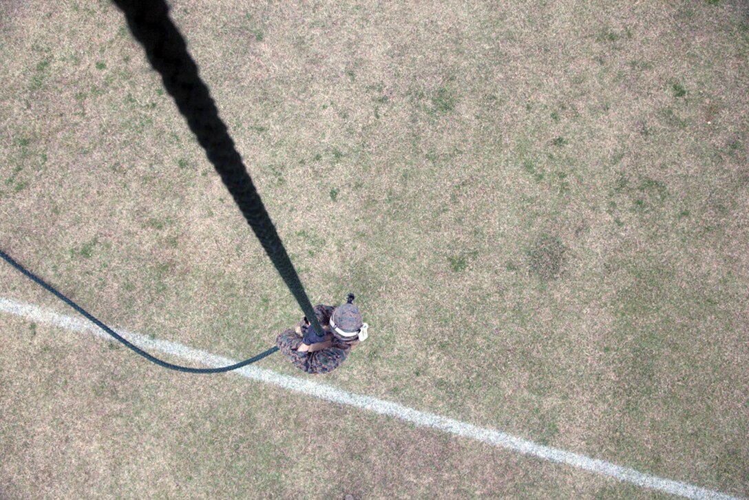 A Marine slides down a rope suspended 30 feet above the ground from a CH-53E Super Stallion helicopter Jan. 8 at Camp Hansen. The rope was suspended from a CH-53E Super Stallion in a precision hover. The Marine was taking part in fast-rope training, where more than 100 Marines familiarized themselves with the essential technique. The Marines are with Battalion Landing Team, 2nd Battalion, 5th Marines, 31st Marine Expeditionary Unit. The helicopter and crew are with Marine Heavy Helicopter Squadron 463, currently assigned to Marine Medium Tiltrotor Squadron 265 (Reinforced), 31st MEU, III MEF. (U.S. Marine Corps photo by Cpl. Natalie M. Rostran/Released)
