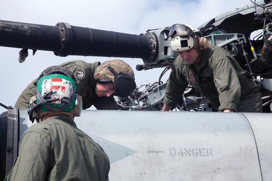 Maj. Neil E. Oswald, center, inspects his CH-53E Super Stallion helicopter with his crew before flying Jan. 8 at Marine Corps Air Station Futenma. Oswald is a CH-53E pilot with HMH-463. (U.S. Marine Corps photo by Cpl. Natalie M. Rostran/Released)