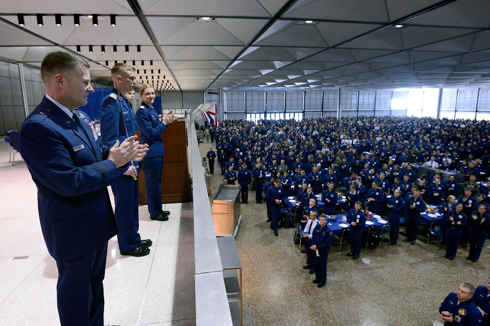 Cadet 1st Class Reuben Luoma-Overstreet (second from left) is applauded by Cadet Wing in Mitchell Hall Tuesday after assuming command of the Cadet Wing. Commandant of Cadets Brig. Gen. Greg Lengyel (left) was the event’s presiding official. Luoma-Overstreet will work with Lengyel to meet the student body’s needs. (U.S. Air Force Photo/Mike Kaplan)