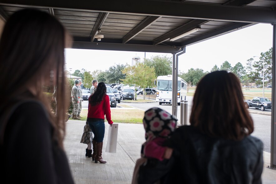 Families watch as the bus carrying their loved ones approaches during a deployment return at Moody Air Force Base, Ga., Jan. 9, 2014. This was one of many groups totaling more than 60 people who returned from Camp Bastion, Afghanistan. (U.S. Air Force photo by Senior Airman Jarrod Grammel/Released)
