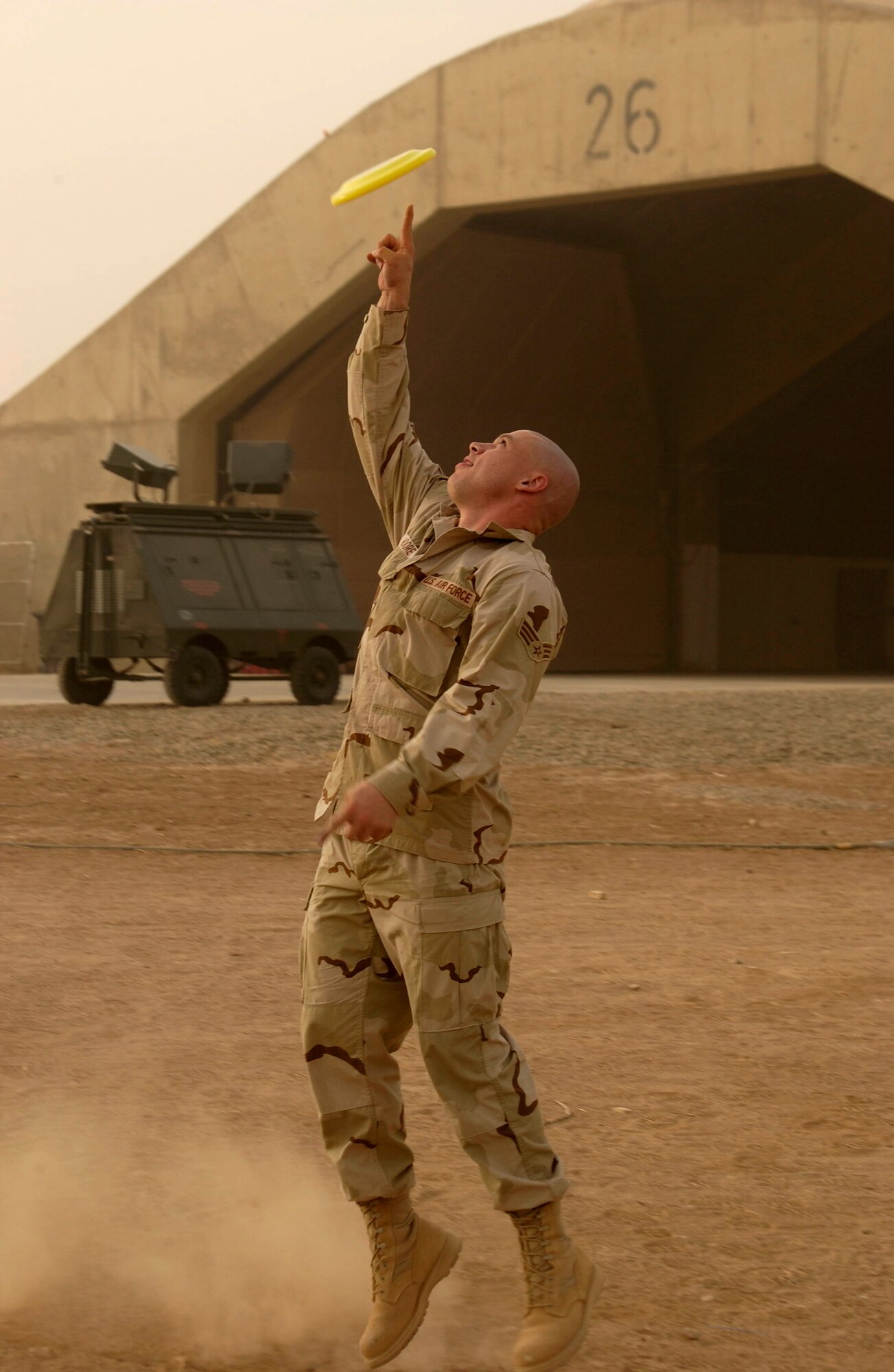 A 188th Fighter Wing Airman takes a break from work to toss around a flying disc in the desert heat while deployed to Balad Air Base, Iraq, in July 2005 as part of Operation Iraqi Freedom. The unit deployed to Balad with 12 F-16C “Fighting Falcon” aircraft, 276 Airmen and support equipment. While in Iraq, the 188th provided close-air support for ground troops, convoy escorts, counter-IED missions and air base defense. (U.S. Air National Guard photo by Senior Master Sgt. Dennis Brambl/188th Fighter Wing Public Affairs)
